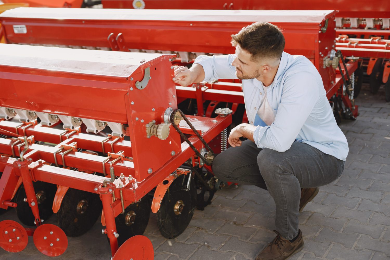 Agronomist choosing a new planter. Man at the outdoor ground of the shop. Agricultural machinery.